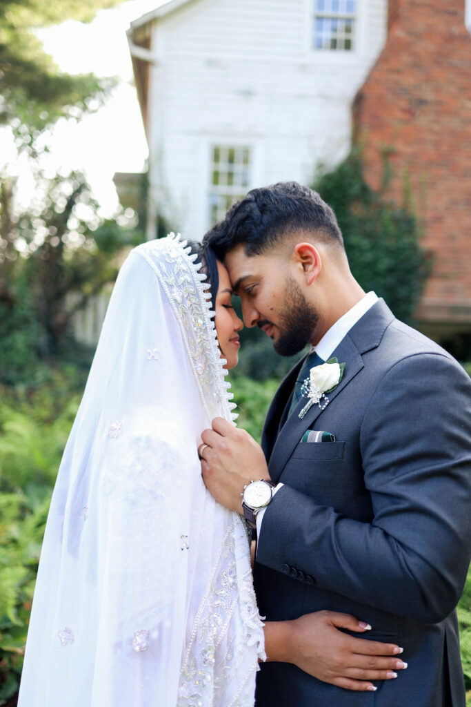bride and groom at farmhouse with gardens