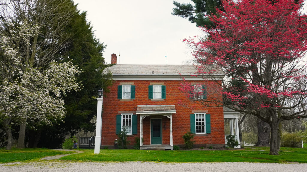 brick farmhouse with flowering trees