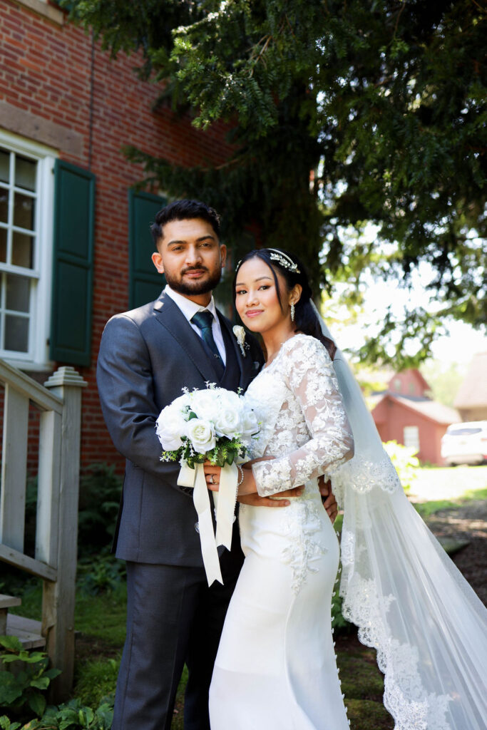 bride and groom at brick farmhouse
