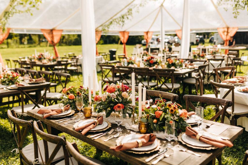 wooden table settings clear outdoor tent reception with greenery & florals