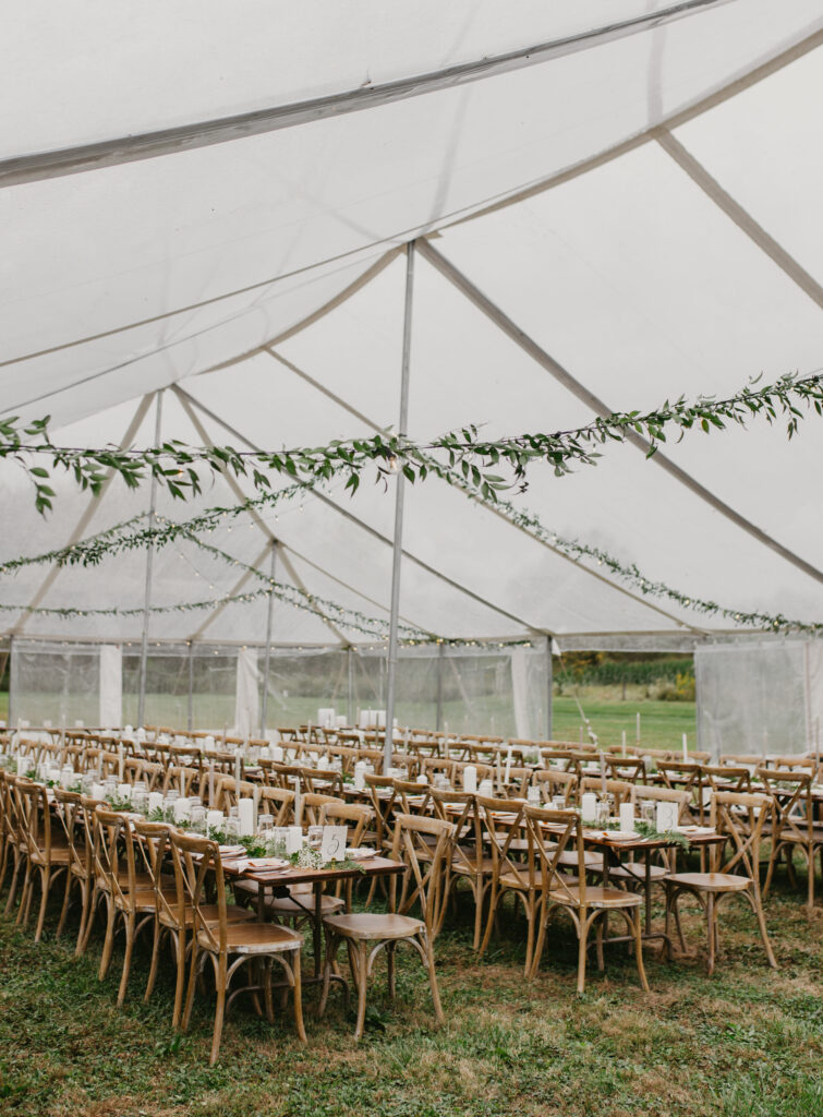 wooden table settings clear outdoor tent reception with greenery
