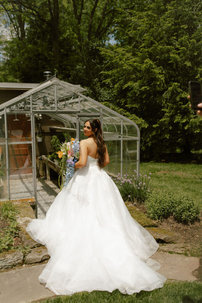 bride with long veil at greenhouse