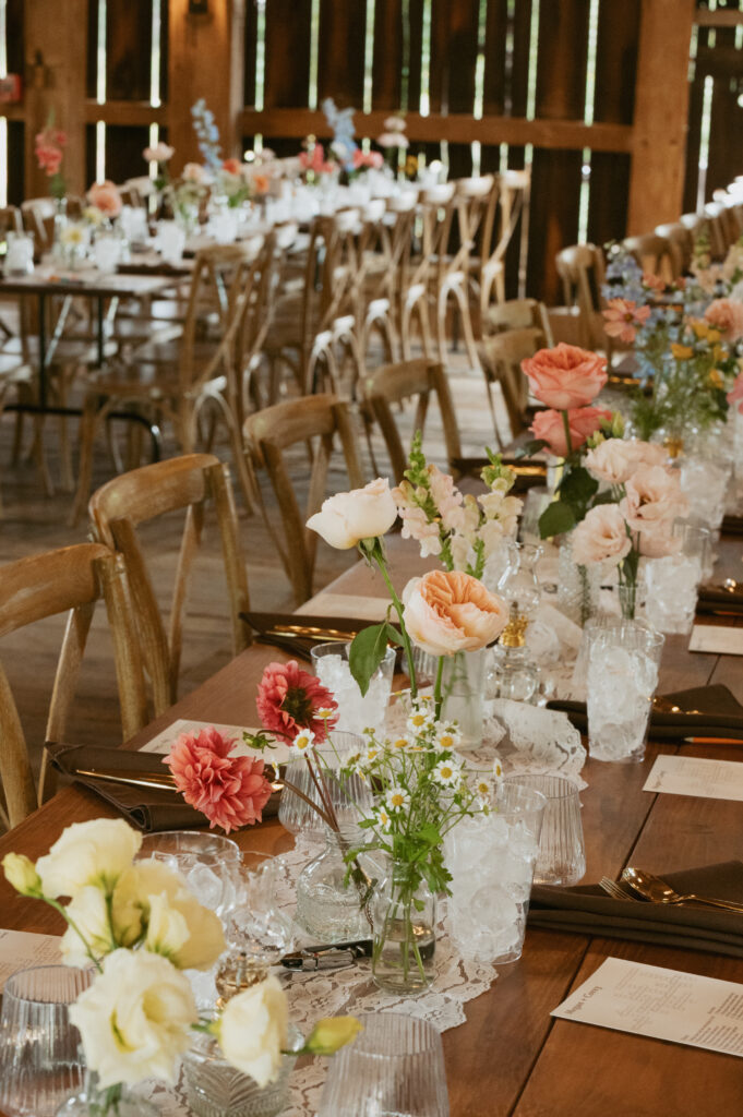 wooden table settings with florals in rustic barn wedding venue