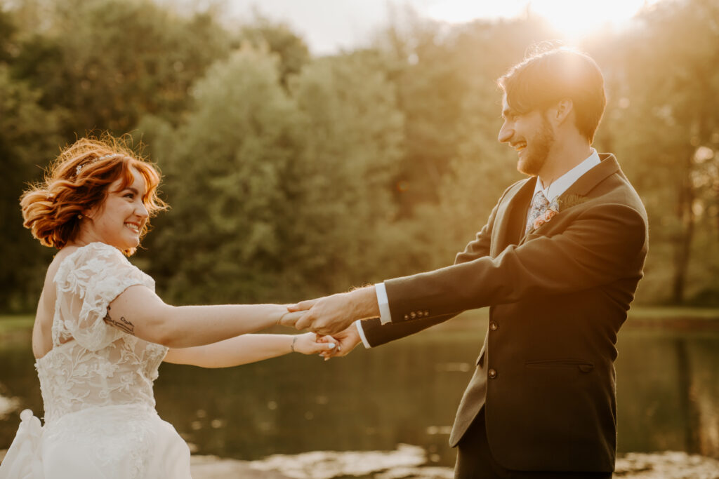 bride and groom beside pond spinning