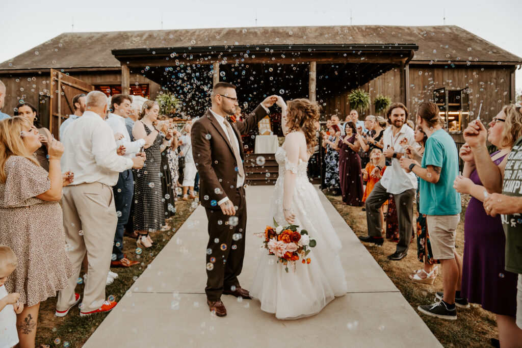 bride and groom bubble exit from rustic Ohio barn wedding venue