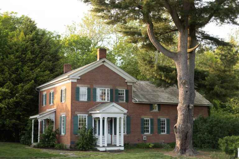 brick farmhouse with trees