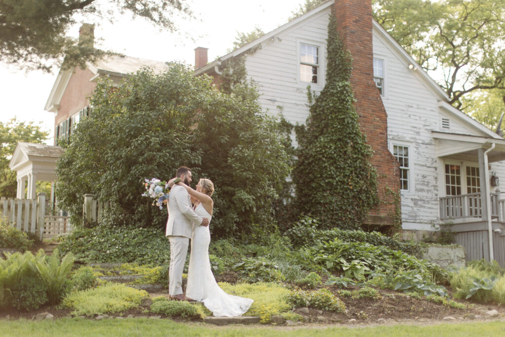 bride and groom at farmhouse with gardens
