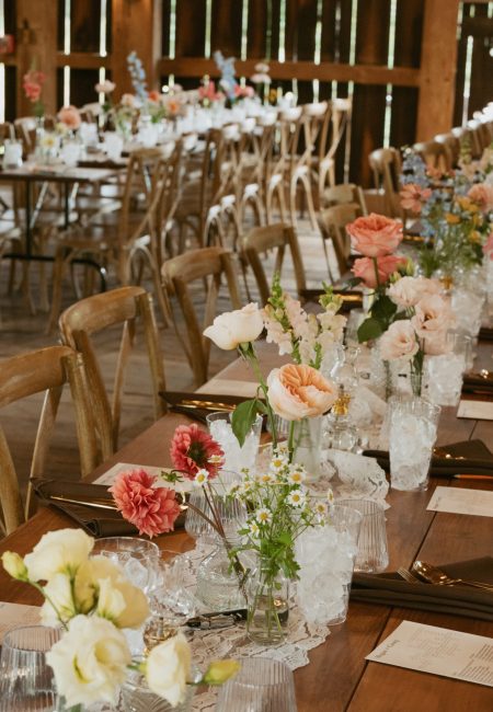 wooden table settings with florals in rustic barn wedding venue